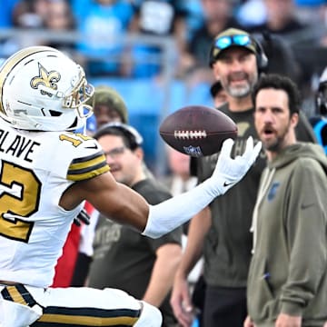 Nov 9, 2025; Charlotte, North Carolina, USA;  New Orleans Saints wide receiver Chris Olave (12) makes a one handed catch as Carolina Panthers cornerback Chau Smith-Wade (26) defends in the fourth quarter at Bank of America Stadium. Mandatory Credit: Bob Donnan-Imagn Images