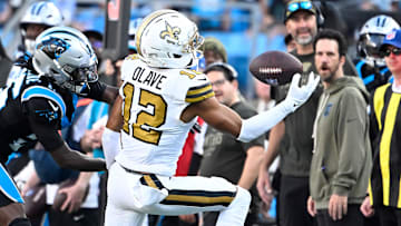 Nov 9, 2025; Charlotte, North Carolina, USA;  New Orleans Saints wide receiver Chris Olave (12) makes a one handed catch as Carolina Panthers cornerback Chau Smith-Wade (26) defends in the fourth quarter at Bank of America Stadium. Mandatory Credit: Bob Donnan-Imagn Images