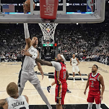 Dec 17, 2023; San Antonio, Texas, USA; San Antonio Spurs forward Victor Wembanyama (1) dunks over New Orleans Pelicans Brandon Ingram (14) during the first half at Frost Bank Center.