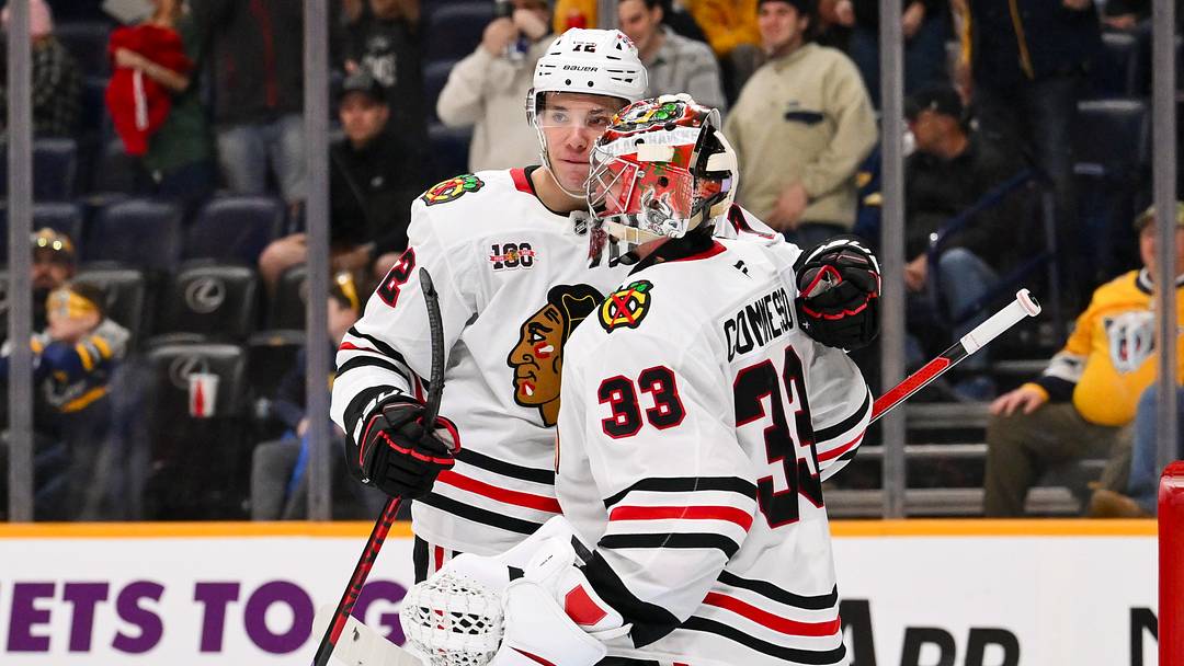 Jan 10, 2026; Nashville, Tennessee, USA;  Chicago Blackhawks goaltender Drew Commesso (33) celebrates the win with defenseman Alex Vlasic (72) against the Nashville Predators during the third period at Bridgestone Arena. Mandatory Credit: Steve Roberts-Imagn Images