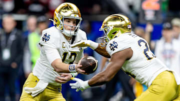 Notre Dame Fighting Irish quarterback Riley Leonard (13) hands off to Notre Dame Fighting Irish running back Jadarian Price (24)