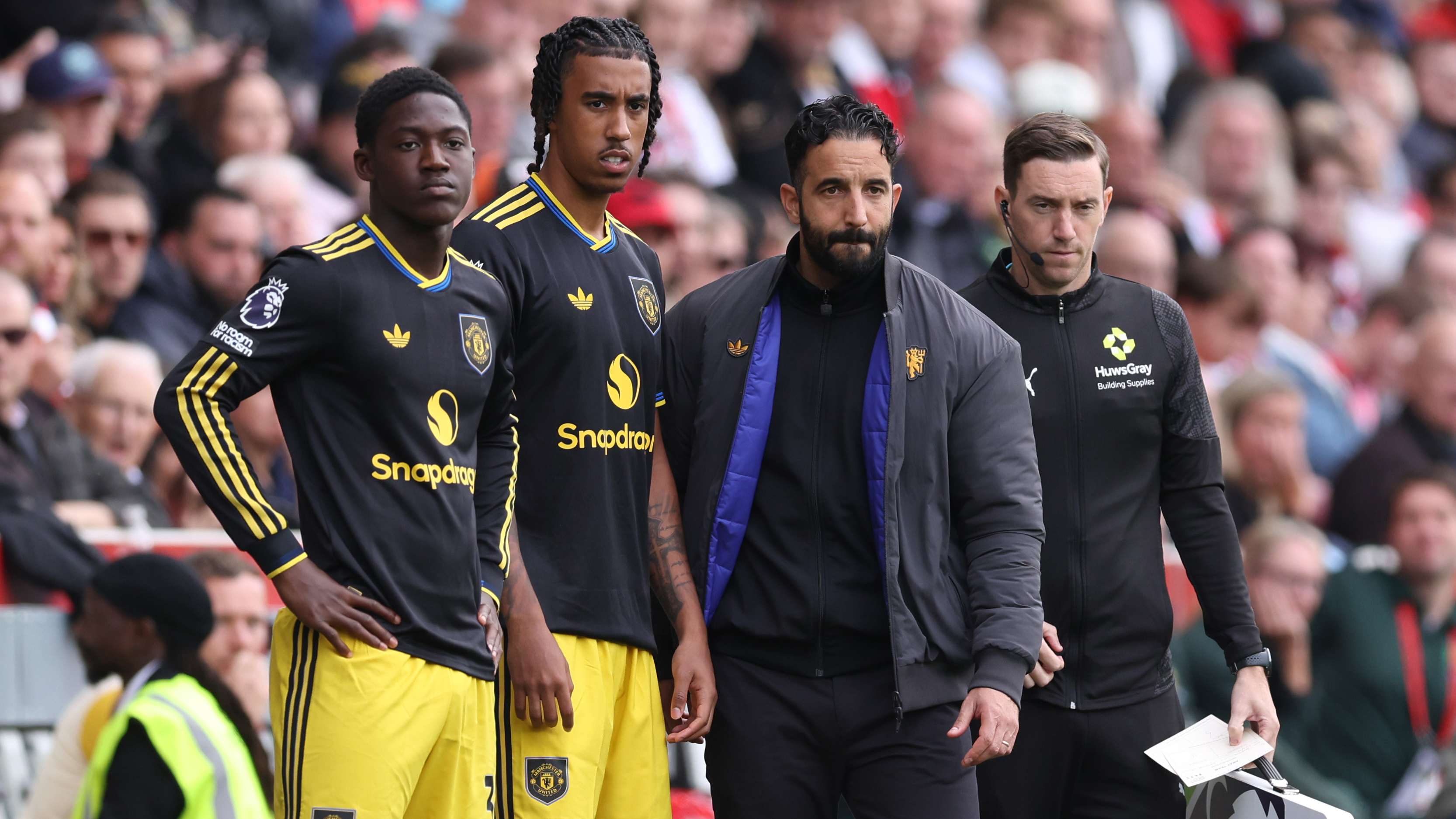 Kobbie Mainoo and Leny Yoro stand alongside Ruben Amorim as they prepare to come on for Manchester United.