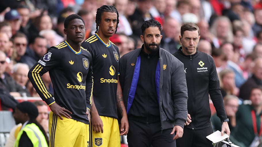 Kobbie Mainoo and Leny Yoro stand alongside Ruben Amorim as they prepare to come on for Manchester United.
