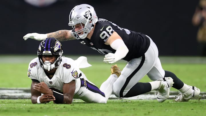 Sep 13, 2021; Paradise, Nevada, USA; Baltimore Ravens quarterback Lamar Jackson (8) is tackled by Las Vegas Raiders defensive end Maxx Crosby (98) during Monday Night Football at Allegiant Stadium. Mandatory Credit: Mark J. Rebilas-Imagn Images