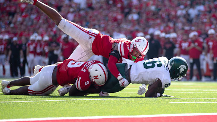 Oct 4, 2025; Lincoln, Nebraska, USA; Nebraska Cornhuskers linebacker Vincent Shavers Jr. (9) and defensive back DeShon Singleton (8) tackle Michigan State Spartans wide receiver Nick Marsh (6) at Memorial Stadium. Mandatory Credit: Kylie Graham-Imagn Images