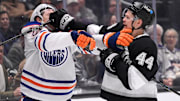 Apr 5, 2025; Los Angeles, California, USA; Edmonton Oilers center Trent Frederic (21) and Los Angeles Kings defenseman Mikey Anderson (44) tangle behind the goal during the first period at Crypto.com Arena. Mandatory Credit: Robert Hanashiro-Imagn Images