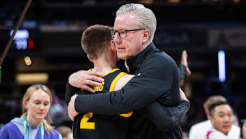 Iowa Hawkeyes head coach Fran McCaffery celebrates with guard Brock Harding (2) 