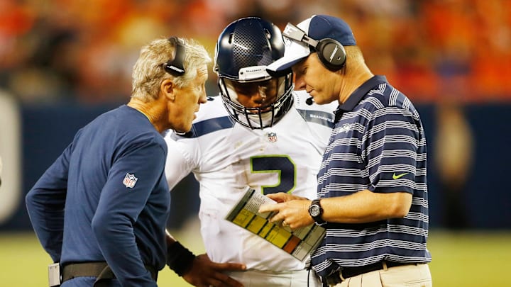 Aug 7, 2014; Denver, CO, USA; Seattle Seahawks quarterback Russell Wilson (3) talks with head coach Pete Carroll (left) and offensive coordinator Darrell Bevell (right) during the game against the Denver Broncos at Sports Authority Field at Mile High. Aug 7, 2014; Denver, CO, USA; Seattle Seahawks quarterback Russell Wilson (3) talks with head coach Pete Carroll (left) and offensive coordinator Darrell Bevell (right) during the game against the Denver Broncos at Sports Authority Field at Mile High.