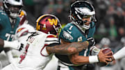 Nov 14, 2024; Philadelphia, Pennsylvania, USA; Philadelphia Eagles quarterback Jalen Hurts (1) is sacked by Washington Commanders linebacker Frankie Luvu (4) Mandatory Credit: Eric Hartline-Imagn Images