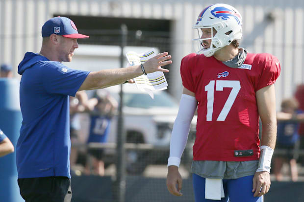 Bills quarterback Josh Allen talks with offensive coordinator Joe Brady between drills.