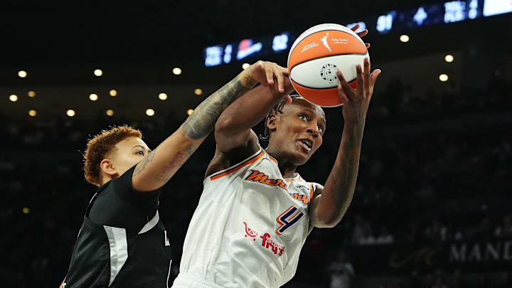 Oct 3, 2025; Las Vegas, Nevada, USA; Phoenix Mercury forward Natasha Mack (4) grabs a rebound in front of Las Vegas Aces forward Kierstan Bell (1) during the third quarter of game one of the 2025 WNBA Finals at Michelob Ultra Arena. Mandatory Credit: Stephen R. Sylvanie-Imagn Images