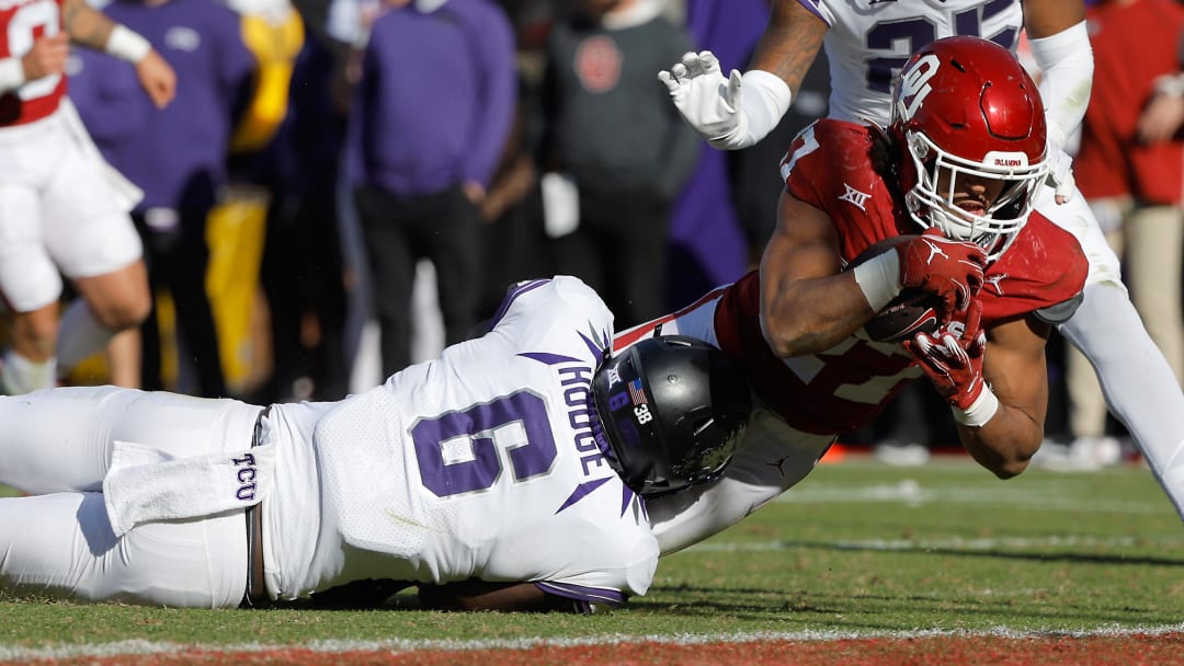 Nov 24, 2023; Norman, Oklahoma, USA; Oklahoma Sooners running back Gavin Sawchuk (27) dives for a touchdown over TCU Horned Frogs linebacker Jamoi Hodge (6) at Gaylord Family-Oklahoma Memorial Stadium. Mandatory Credit: Bryan Terry-USA TODAY Sports