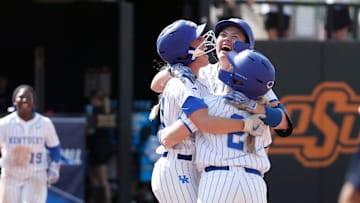 Kentucky's Ally Hutchins (7), facing camera, celebrates with Erin Coffel (21) and Grace Lorsung (33) after driving in the game-winning run in the seventh inning of a softball game against Michigan in the first round of the Stillwater Regional of the NCAA Tournament in Stillwater, Okla., Friday, May 17, 2024.