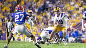 Sep 13, 2025; Baton Rouge, Louisiana, USA;  LSU Tigers quarterback Garrett Nussmeier (18) scrambles against Florida Gators defensive back Dijon Johnson (27) during the first half at Tiger Stadium. Mandatory Credit: Stephen Lew-Imagn Images