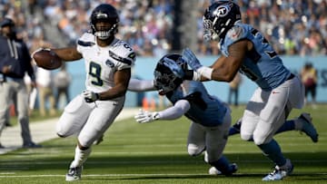 Nov 23, 2025; Nashville, Tennessee, USA; Seattle Seahawks running back Kenneth Walker III (9) runs against Tennessee Titans cornerback Jalyn Armour-Davis (18) and linebacker Cedric Gray (33) during the first half at Nissan Stadium.