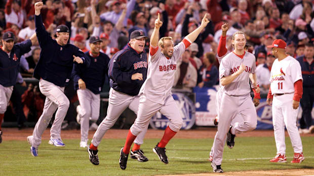 Members of the Boston Red Sox rush out of the dugout to celebrate their World Series win over the Cardinals in 2004.