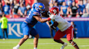 Oct 19, 2024; Kansas City, Missouri, USA; Kansas Jayhawks offensive lineman Logan Brown (52) faces off with Houston Cougars defensive lineman Keith Cooper Jr. (5) during the second quarter at GEHA Field at Arrowhead Stadium.