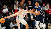 Cincinnati Bearcats guard Connor Hickman (8) attempts to grab at a loose ball in the first half of a college basketball game between the Cincinnati Bearcats and Howard Bison, Sunday, Dec. 8, 2024, at Fifth Third Arena in Cincinnati.