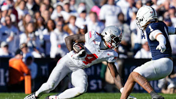 Ohio State Buckeyes wide receiver Jeremiah Smith (4) loses his footing on the grass turf as he tries to elude Penn State Nittany Lions safety Jaylen Reed (1) after making a catch during the NCAA football game at Beaver Stadium in University Park, Pa. on Monday, Nov. 4, 2024. Ohio State won 20-13.