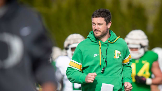 Oregon head coach Dan Lanning runs during practice