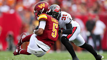 Sep 8, 2024; Tampa, Florida, USA; Washington Commanders quarterback Jayden Daniels (5) is hit by Tampa Bay Buccaneers safety Antoine Winfield Jr. (31) in the second quarter at Raymond James Stadium. Mandatory Credit: Nathan Ray Seebeck-Imagn Images