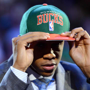 June 28, 2012; Newark, NJ, USA; John Henson (North Carolina) puts on a cap after being introduced as the number fourteen overall pick to the Milwaukee Bucks during the 2012 NBA Draft at the Prudential Center.  Mandatory Credit: Jerry Lai-Imagn Images