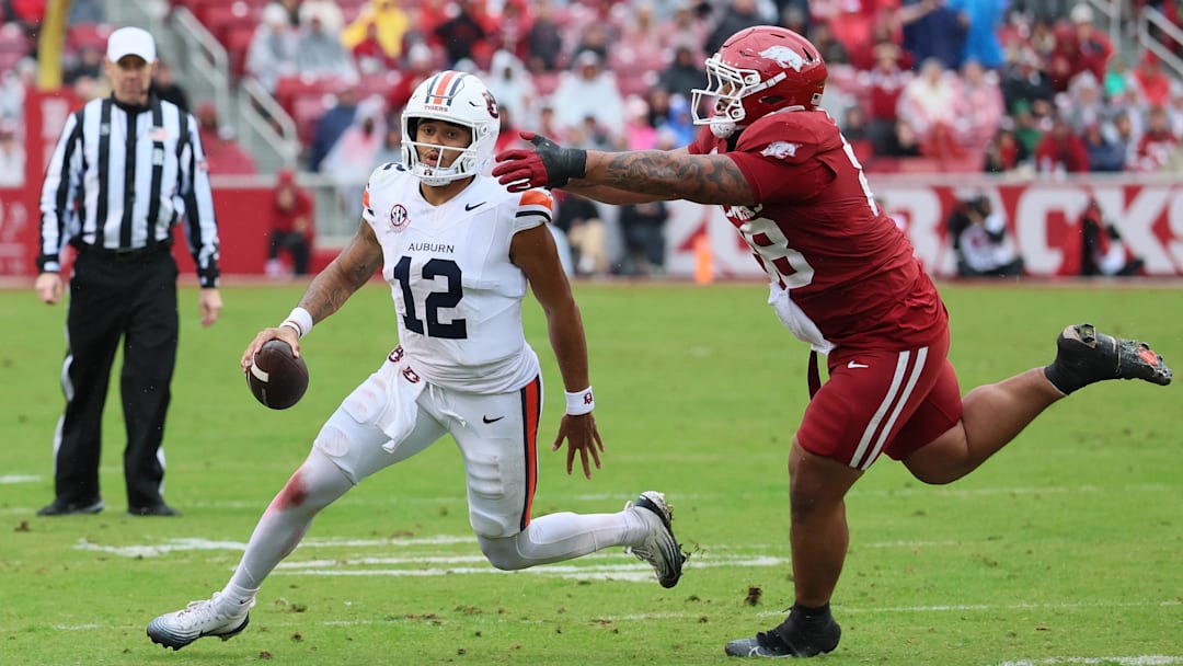 Oct 25, 2025; Fayetteville, Arkansas, USA; Auburn Tigers quarterback Ashton Daniels (12) rushes during the third quarter as Arkansas Razorbacks defensive tackle Danny Saili (88) defends at Donald W. Reynolds Razorback Stadium. Auburn won 33-24. Mandatory Credit: Nelson Chenault-Imagn Images Oct 25, 2025; Fayetteville, Arkansas, USA; Auburn Tigers quarterback Ashton Daniels (12) rushes during the third quarter as Arkansas Razorbacks defensive tackle Danny Saili (88) defends at Donald W. Reynolds Razorback Stadium. Auburn won 33-24. Mandatory Credit: Nelson Chenault-Imagn Images