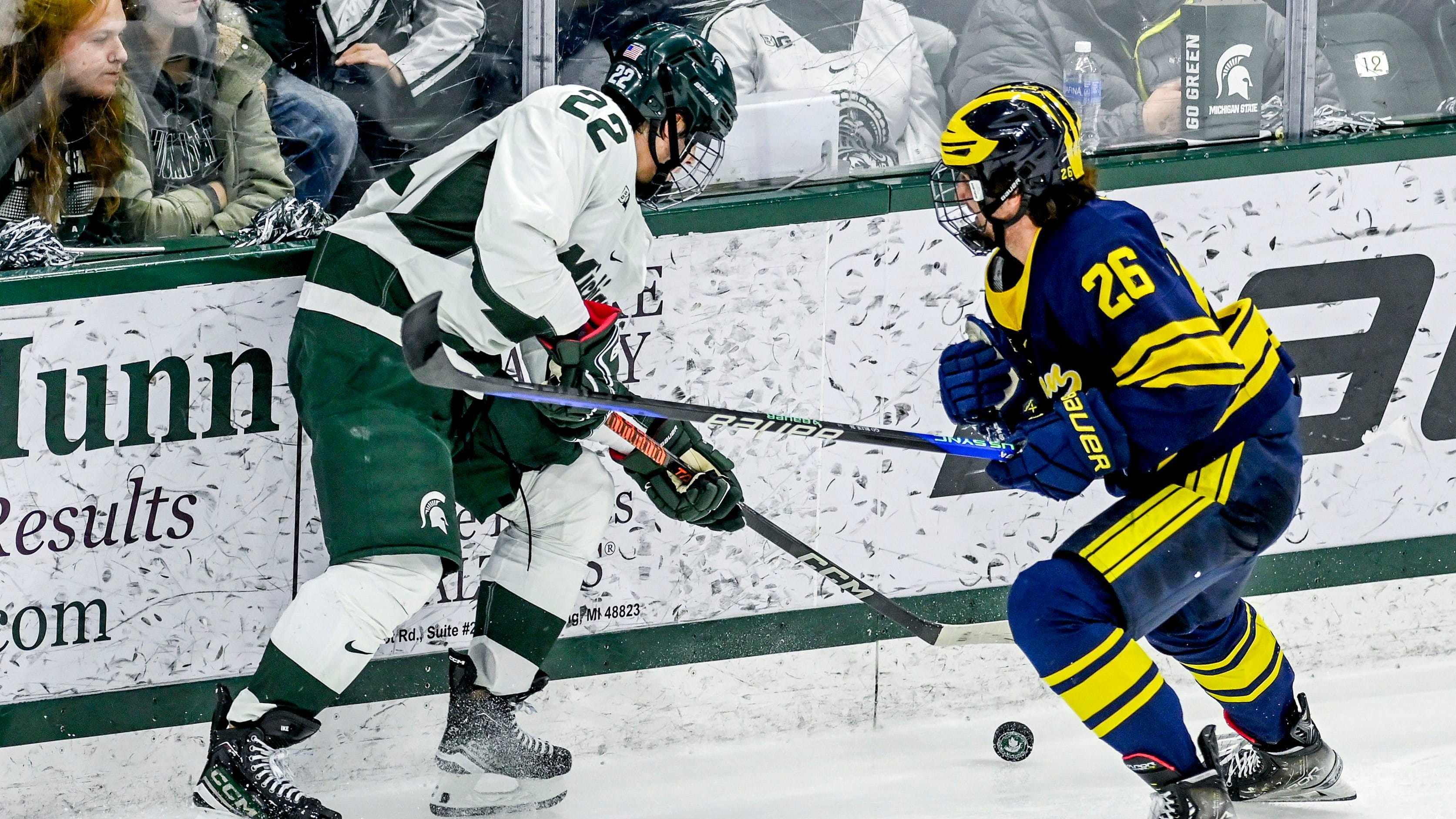 Michigan State's Isaac Howard, Michigan's Seamus Casey go after the puck during a matchup between the Spartans and Wolverines