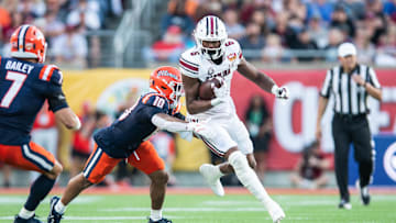 Dec 31, 2024; Orlando, FL, USA; South Carolina Gamecocks running back Dylan Stewart (6) runs the ball against Illinois Fighting Illini defensive back Miles Scott (10) in the third quarter at Camping World Stadium. Mandatory Credit: Jeremy Reper-Imagn Images