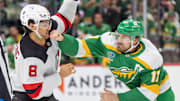 Mar 29, 2025; Saint Paul, Minnesota, USA; New Jersey Devils defenseman Johnathan Kovacevic (8) catches a right hand to the chin from Minnesota Wild left wing Marcus Foligno (17) during fight in the second period at Xcel Energy Center. Mandatory Credit: Matt Blewett-Imagn Images