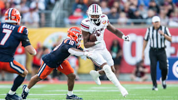 Dec 31, 2024; Orlando, FL, USA; South Carolina Gamecocks running back Dylan Stewart (6) runs the ball against Illinois Fighting Illini defensive back Miles Scott (10) in the third quarter at Camping World Stadium. Mandatory Credit: Jeremy Reper-Imagn Images