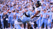 Nov 22, 2025; Chapel Hill, North Carolina, USA; Duke Blue Devils wide receiver Jayden Moore (8) twists from a tackle by North Carolina Tar Heels defensive back Gavin Gibson (5) during the first half at Kenan Stadium. Mandatory Credit: William Howard-Imagn Images