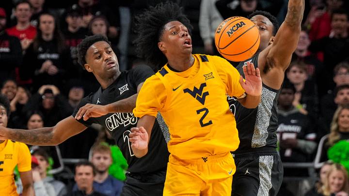 Feb 5, 2026; Cincinnati, Ohio, USA;  West Virginia Mountaineers guard Amir Jenkins (2) steals the ball away from Cincinnati Bearcats guard Jizzle James (2) and forward Jalen Celestine (32) in the second half at Fifth Third Arena. Mandatory Credit: Aaron Doster-Imagn Images