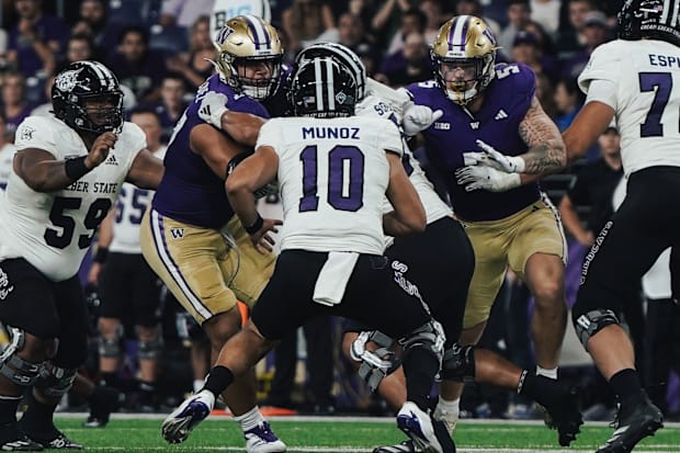 Sebastian Valdez (50) and Zach Durfee (5) come after Weber State quarterback Richie Munoz with a fierce pass rush. 