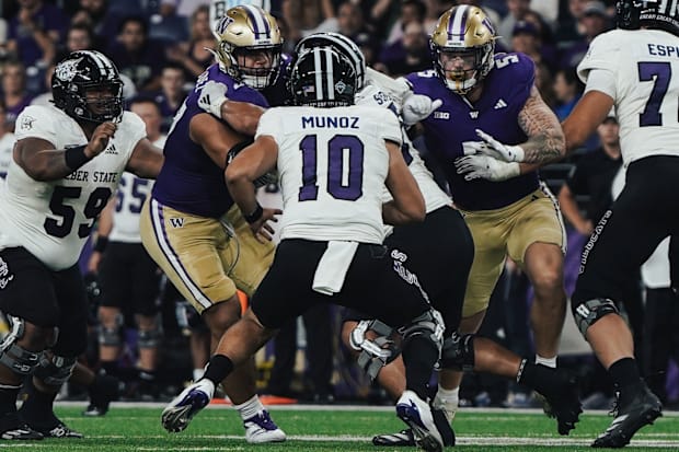 Sebastian Valdez (50) and Zach Durfee (5) provide a fierce pass rush against Weber State's Richie Munoz. 