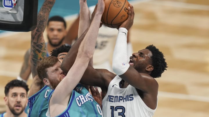 Feb 10, 2024; Charlotte, North Carolina, USA; Charlotte Hornets forward Davis Bertans (9) takes an elbow blocking a shot by Memphis Grizzlies forward Jaren Jackson Jr. (13) during the second half at Spectrum Center. Mandatory Credit: Jim Dedmon-USA TODAY Sports