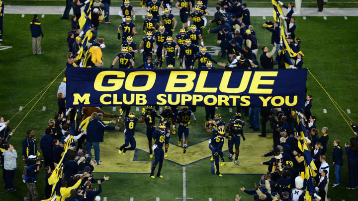 Oct 11, 2014; Ann Arbor, MI, USA; Michigan Wolverines run under the banner prior to the game against the Penn State Nittany Lions at Michigan Stadium. Mandatory Credit: Andrew Weber-USA TODAY Sports