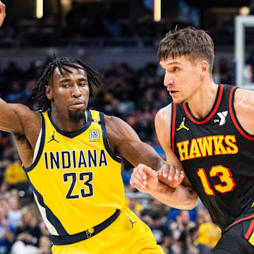 Apr 14, 2024; Indianapolis, Indiana, USA; Atlanta Hawks guard Bogdan Bogdanovic (13) dribbles the ball while  Indiana Pacers forward Aaron Nesmith (23) defends in the second half at Gainbridge Fieldhouse. Mandatory Credit: Trevor Ruszkowski-Imagn Images