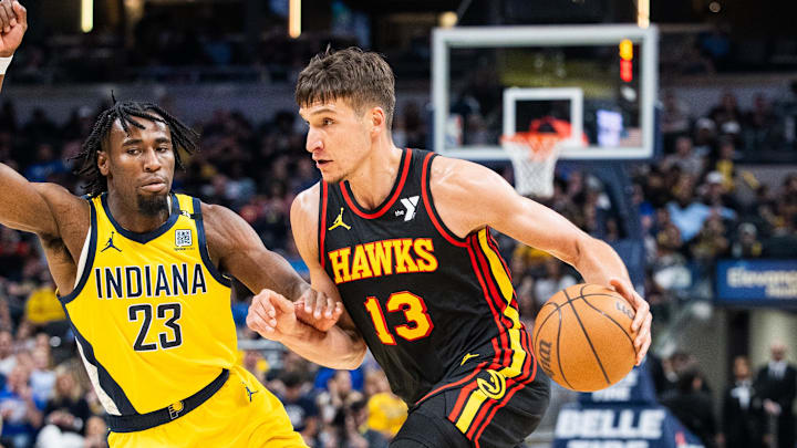 Apr 14, 2024; Indianapolis, Indiana, USA; Atlanta Hawks guard Bogdan Bogdanovic (13) dribbles the ball while  Indiana Pacers forward Aaron Nesmith (23) defends in the second half at Gainbridge Fieldhouse. Mandatory Credit: Trevor Ruszkowski-Imagn Images