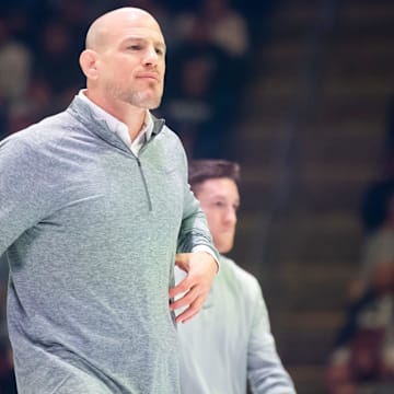 Penn State wrestling coach Cael Sanderson walks onto the mat  during a Nittany Lions match in State College.
