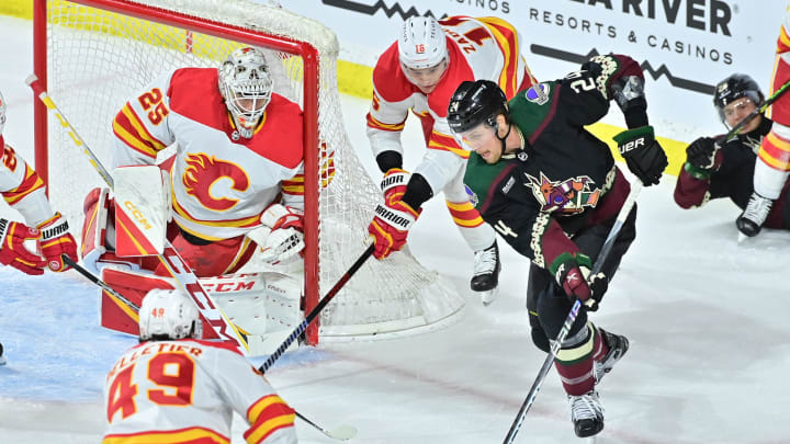 Mar 14, 2023; Tempe, Arizona, USA; Arizona Coyotes right wing Brett Ritchie (24) shoots the puck as Calgary Flames left wing Jakob Pelletier (49), defenseman Nikita Zadorov (16) and goaltender Jacob Markstrom (25) defend in the first period at Mullett Arena. Mandatory Credit: Matt Kartozian-USA TODAY Sports