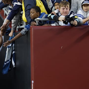 Dallas Cowboys wide receiver KaVontae Turpin shakes hands with fans while leaving the field after the Cowboys' game.