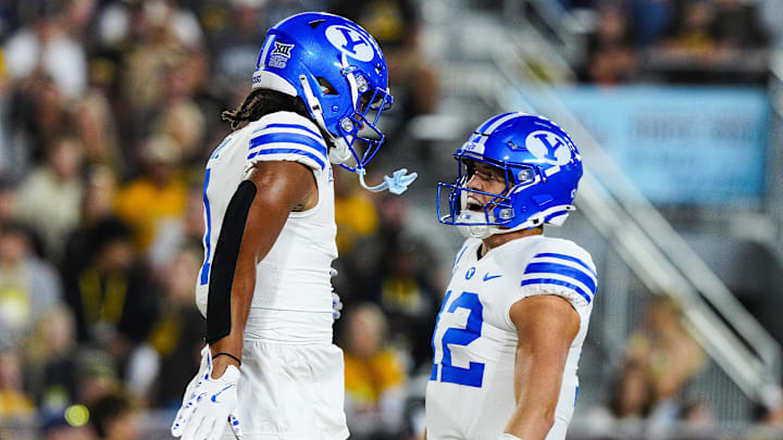 Sep 14, 2024; Laramie, Wyoming, USA; Brigham Young Cougars tight end Keanu Hill (1) celebrates a touchdown with quarterback Jake Retzlaff (12) against the Wyoming Cowboys during the first quarter at Jonah Field at War Memorial Stadium.