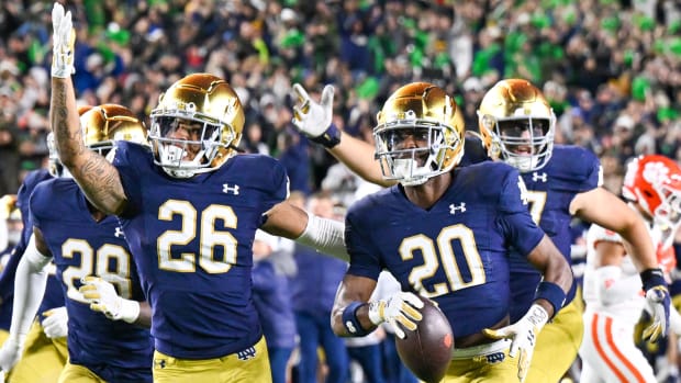 Notre Dame Fighting Irish players celebrate a play on defense during a college football game.