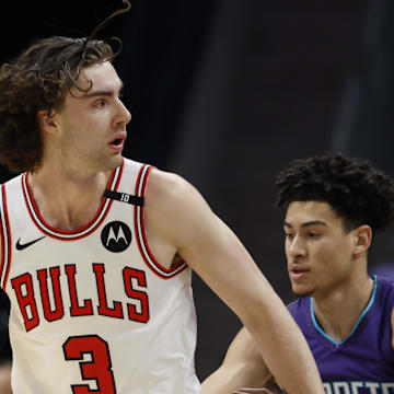 Apr 6, 2025; Charlotte, North Carolina, USA; Chicago Bulls guard Josh Giddey (3) looks to pass against Charlotte Hornets guard KJ Simpson (25) during the first quarter at Spectrum Center. Mandatory Credit: Nell Redmond-Imagn Images