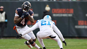 Dec 22, 2024; Chicago, Illinois, USA; Chicago Bears running back D'Andre Swift (4) rushes teh ball against Detroit Lions cornerback Amik Robertson (21) during the second half at Soldier Field. Mandatory Credit: Mike Dinovo-Imagn Images