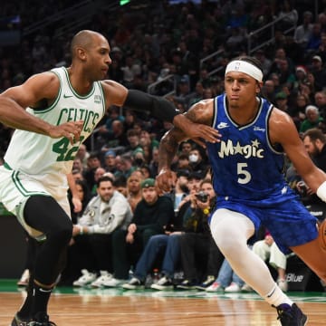 Dec 17, 2023; Orlando Magic forward Paolo Banchero (5) dribbles the ball while Boston Celtics center Al Horford (42) defends during the first half at TD Garden. 