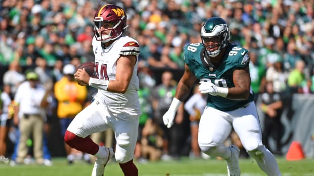 Washington Commanders quarterback Sam Howell (14) runs past Philadelphia Eagles defensive tackle Jalen Carter