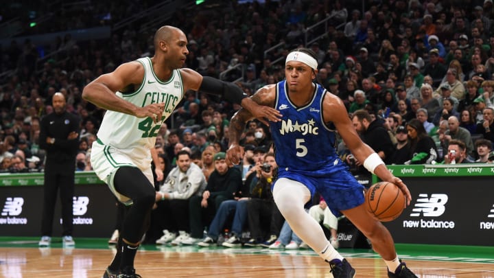 Dec 17, 2023; Orlando Magic forward Paolo Banchero (5) dribbles the ball while Boston Celtics center Al Horford (42) defends during the first half at TD Garden. 