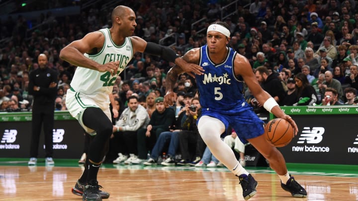 Dec 17, 2023; Orlando Magic forward Paolo Banchero (5) dribbles the ball while Boston Celtics center Al Horford (42) defends during the first half at TD Garden.